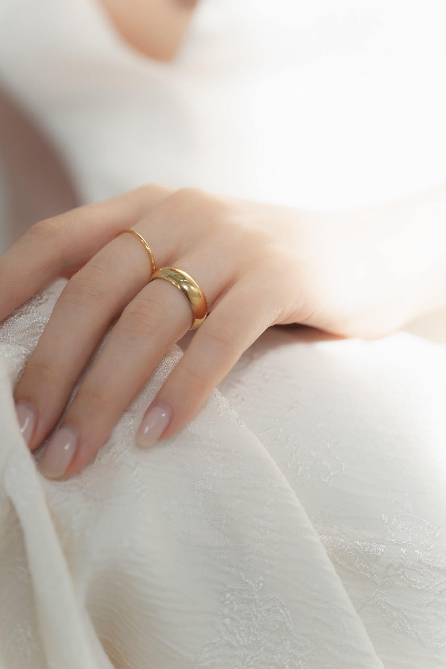 1mmプレーンリングを着用した女性の手元のクローズアップ。シンプルで洗練されたデザインのステンレス製リング。
