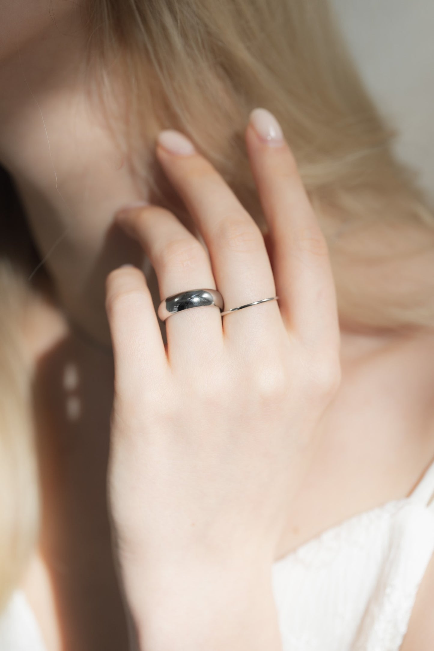 1mmプレーンリングを着用した女性の手元のクローズアップ。シンプルで洗練されたデザインのステンレス製リング。