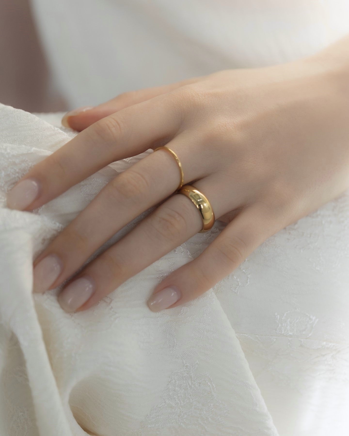 1mmプレーンリングを着用した女性の手元のクローズアップ。シンプルで洗練されたデザインのステンレス製リング。
