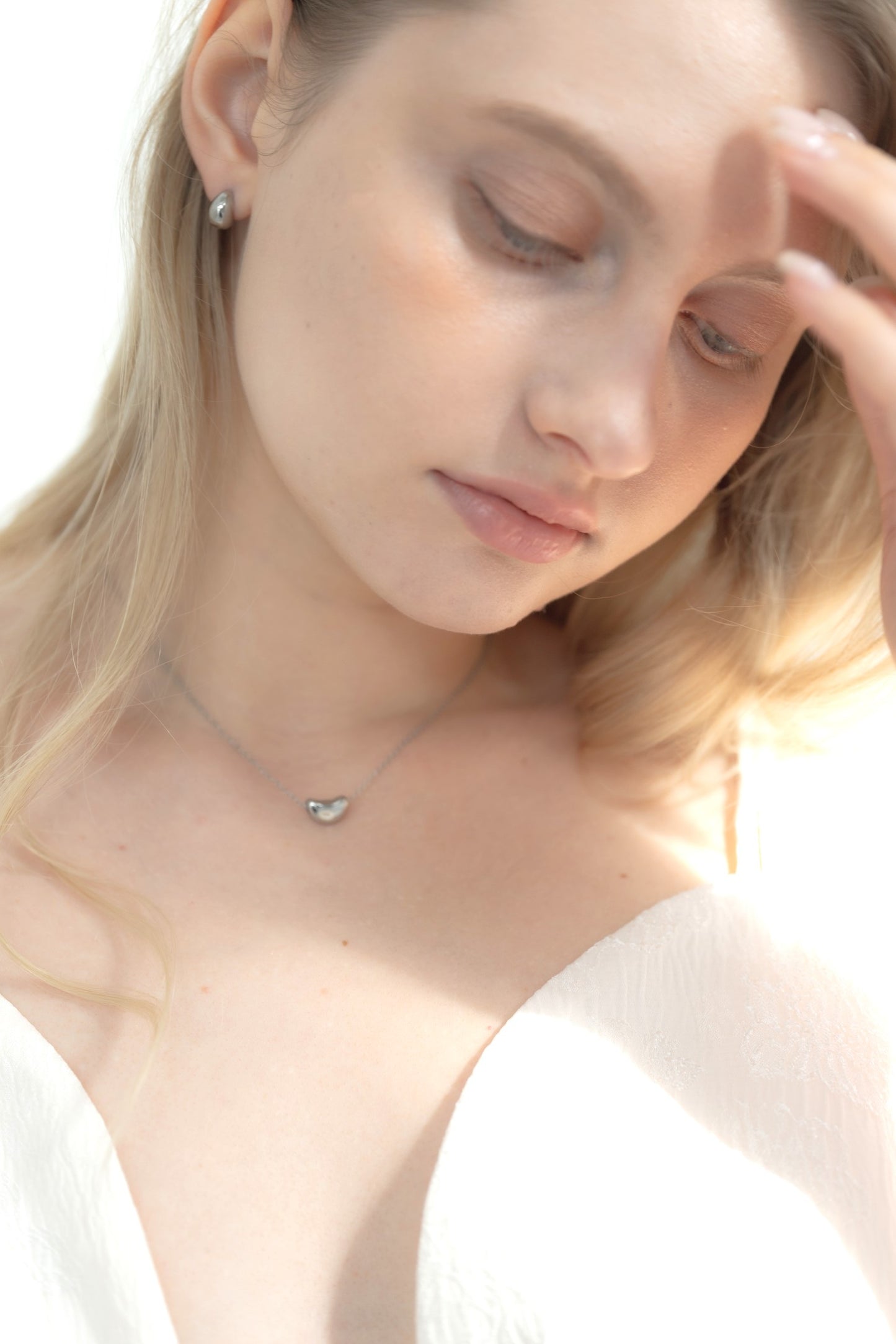 他のジュエリーと一緒にドロップピアスを着用する女性。重ね付けにも最適なアクセサリー。