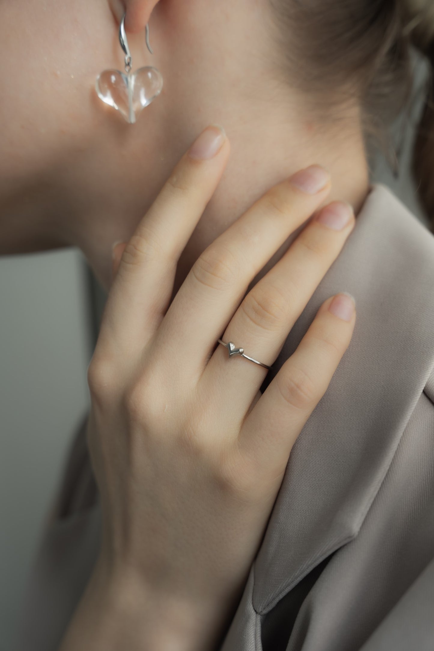 ミニハートリングを着用した女性の横顔。小ぶりでシンプルなデザインが、日常使いにも最適なアクセサリー。