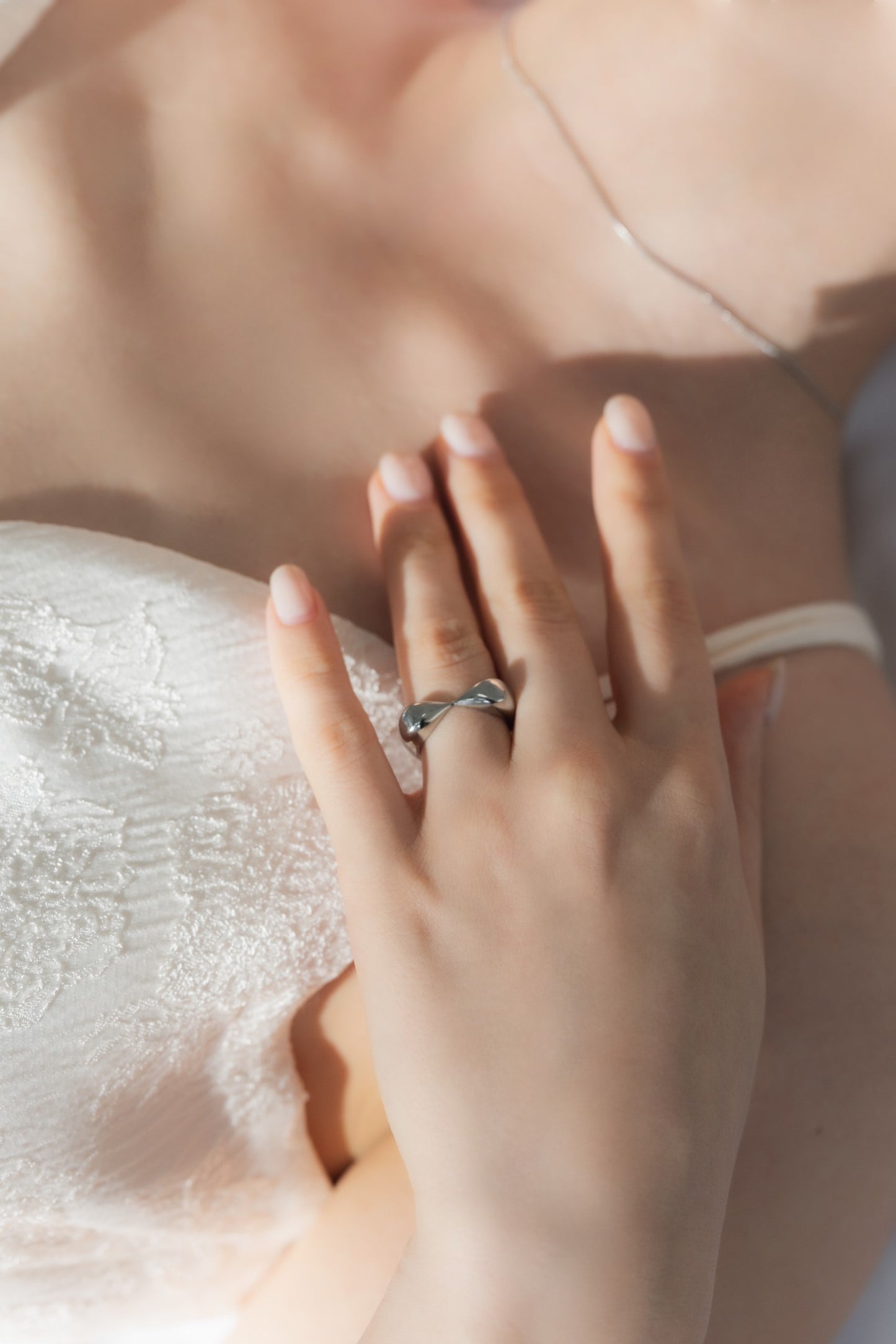 ニュアンスハートリングを着用する女性。シンプルでありながら個性を引き立てるデザイン。