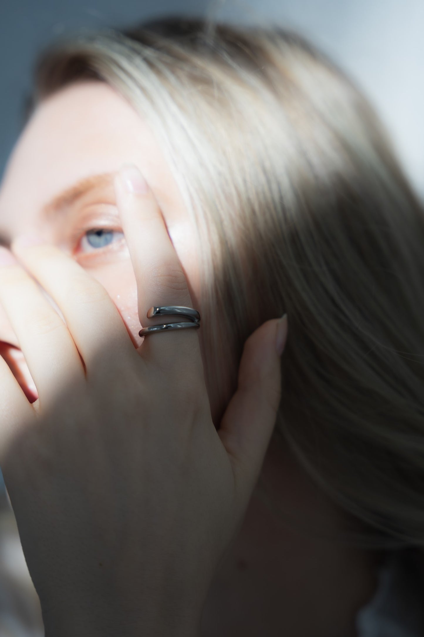 シンプルニュアンスリングを着用した女性の手元のクローズアップ。洗練されたステンレス製のシンプルなデザイン。