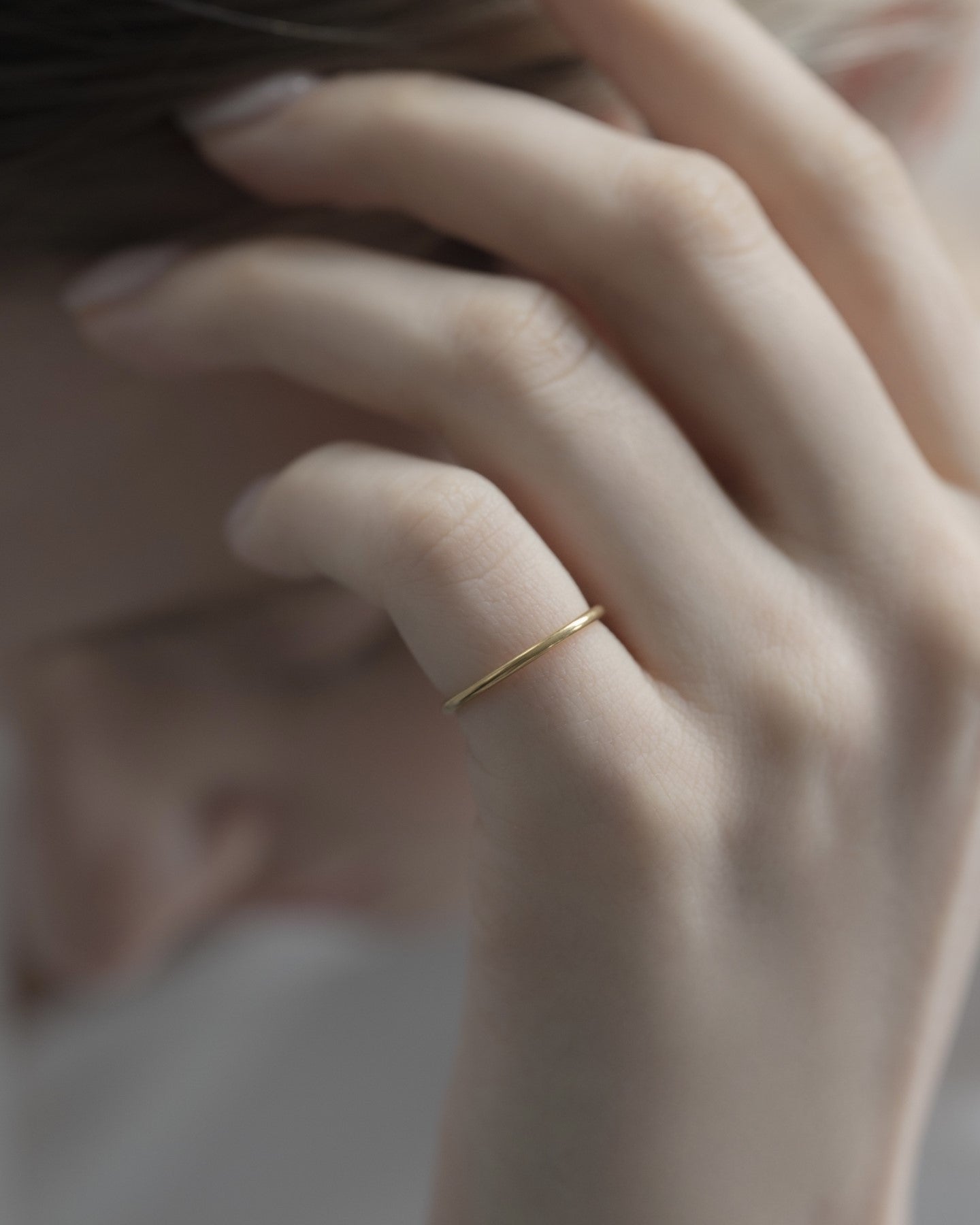 シンプルピンキーリングを着用した女性の手元のクローズアップ。洗練されたステンレス製デザインのピンキーリング。
