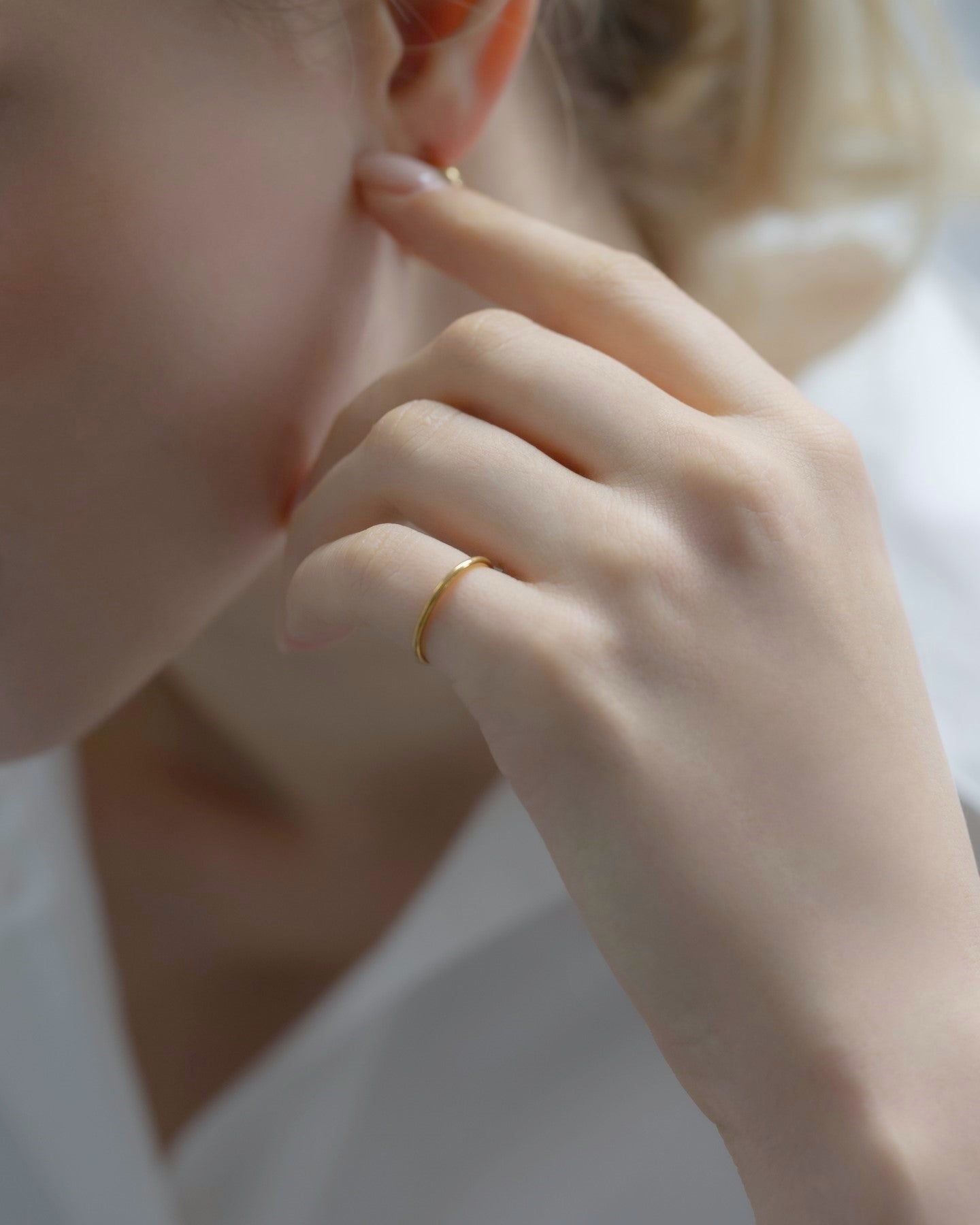 シンプルピンキーリングを着用した女性の手元のクローズアップ。洗練されたステンレス製デザインのピンキーリング。