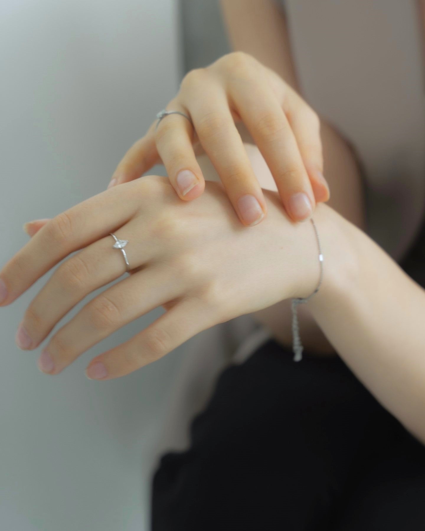シンプルジルコニアリングを着用した女性の手元のクローズアップ。洗練されたデザインでジルコニアが指先に輝きを添えるアクセサリー。