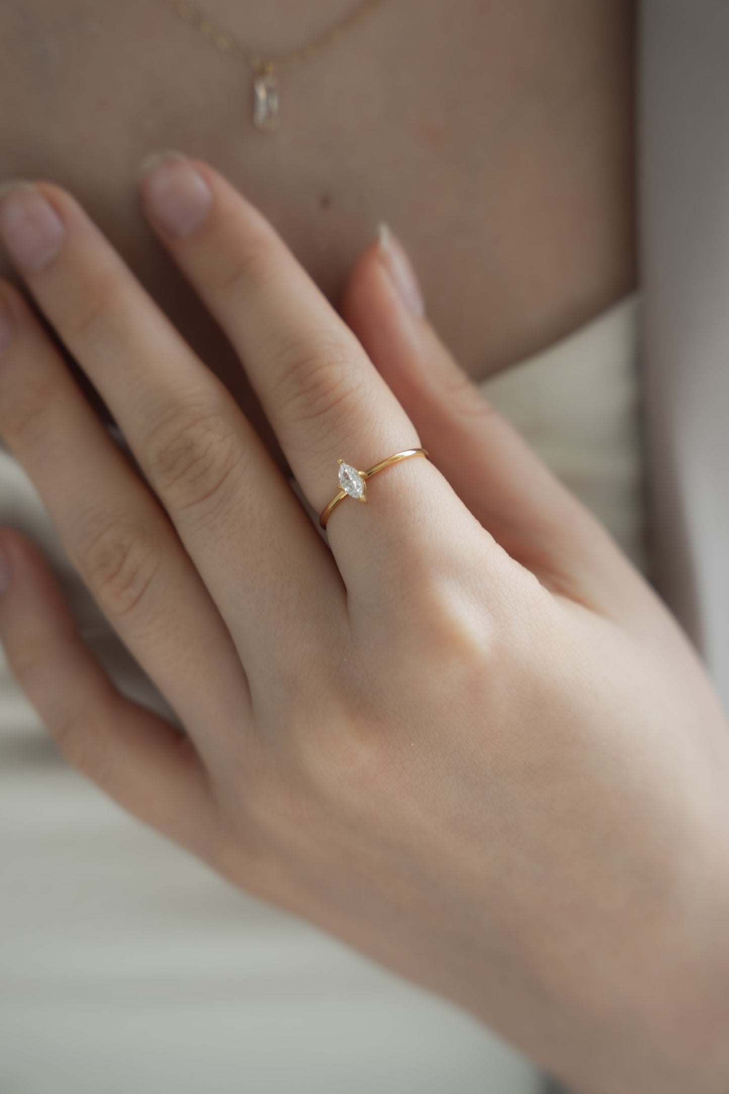 他のジュエリーと一緒にシンプルジルコニアリングを着用する女性。シンプルなデザインで、重ね付けにも最適なリング。
