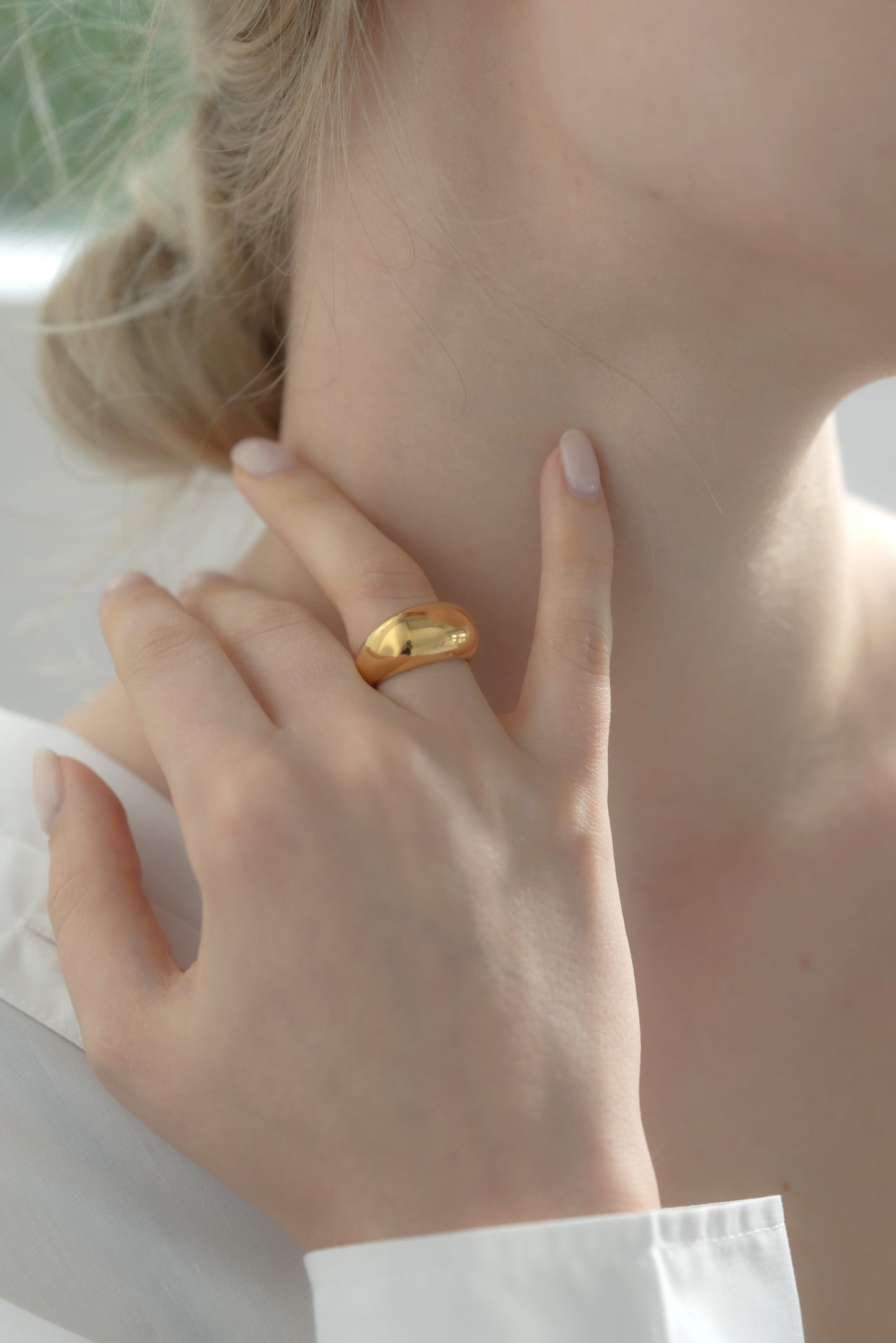横顔から見たボリュームニュアンスリングを着用する女性。シンプルでスタイリッシュなステンレス製リング。